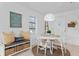 Charming dining area features white shiplap walls, a round table, and a cozy bench with storage at 2215 Thrace St, Tampa, FL 33605