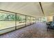 Spacious screened-in porch with brick flooring and views of the lush backyard at 23701 Harmony Ln, Land O Lakes, FL 34639