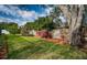 A well-maintained backyard featuring a lush lawn, colorful plantings, and a wood fence for privacy at 2392 Hillcreek E Cir, Clearwater, FL 33759