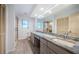 Spacious bathroom features dual sinks, granite countertops, glass shower door, and wood look tile flooring at 2392 Hillcreek E Cir, Clearwater, FL 33759