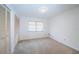 Clean bedroom features neutral carpet and a window with coverings, as well as a closet with folding doors at 2392 Hillcreek E Cir, Clearwater, FL 33759