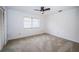 Clean bedroom features neutral carpet, ceiling fan and light fixture, and a window with coverings at 2392 Hillcreek E Cir, Clearwater, FL 33759