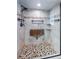 Beautiful shower featuring pebble floor, grab bar, and built-in seat and shelf, all surrounded by decorative tile at 2392 Hillcreek E Cir, Clearwater, FL 33759