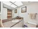 Bathroom featuring a single sink vanity, white cabinets, earth tone tile and shower with curtain at 2427 Twin Dr # 2, Sarasota, FL 34234