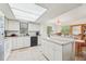 Bright kitchen with skylight, white cabinets, appliances, tile flooring, and breakfast bar at 2427 Twin Dr # 2, Sarasota, FL 34234