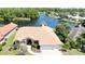 Aerial view of a well-manicured home featuring a 3 car garage with a view of the lake at 2679 Saddlewood Ln, Palm Harbor, FL 34685