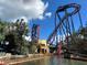 Coaster with red track looping around building in amusement park with water feature in foreground at 2679 Saddlewood Ln, Palm Harbor, FL 34685