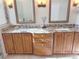 Bathroom with double vanity, granite counters, wood cabinets, and decorative mirrors at 2679 Saddlewood Ln, Palm Harbor, FL 34685