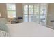 Bedroom with shuttered windows, a view of the screened lanai, and a console table beneath a mounted television at 2679 Saddlewood Ln, Palm Harbor, FL 34685