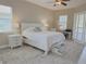 Comfortable bedroom with a white bed, a bedside table, a desk, and shuttered windows for natural light at 2679 Saddlewood Ln, Palm Harbor, FL 34685
