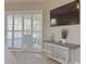 Bedroom with shutters to the lanai, a flat screen TV, and a console table with decorations below at 2679 Saddlewood Ln, Palm Harbor, FL 34685