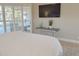 Bedroom featuring a mounted television, console table, and shuttered windows with a view of the screened lanai at 2679 Saddlewood Ln, Palm Harbor, FL 34685