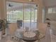 Dining area with a glass-top table and wicker chairs, offering views of the screened lanai and pool at 2679 Saddlewood Ln, Palm Harbor, FL 34685