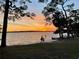 Waterfront beach at sunset with people walking on the beach and sunset views at 2679 Saddlewood Ln, Palm Harbor, FL 34685