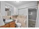 Functional bathroom featuring a single sink, a toilet, tiled walls, and a shower/tub combo with a shower curtain at 3027 Burlington N Ave, St Petersburg, FL 33713