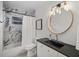 Updated bathroom featuring a round mirror, black countertop and white shower curtain at 3027 Burlington N Ave, St Petersburg, FL 33713