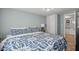 Comfortable bedroom featuring blue and white patterned bedding, soft lighting, and closet for ample storage at 3027 Burlington N Ave, St Petersburg, FL 33713
