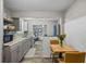 Open concept kitchen with gray cabinets, wood-look flooring, granite countertops, and a dining area with a wooden table at 3027 Burlington N Ave, St Petersburg, FL 33713
