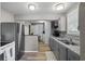 The kitchen has gray cabinets, granite countertops, a stainless steel refrigerator and wood-look vinyl flooring at 3027 Burlington N Ave, St Petersburg, FL 33713