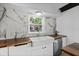 Bright kitchen features a window view above the sink, white cabinets, wood countertops, and marble backsplash at 3027 Burlington N Ave, St Petersburg, FL 33713