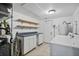 Well-lit laundry room with washer, dryer, shelving, and a utility sink for added convenience at 3027 Burlington N Ave, St Petersburg, FL 33713