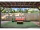 A cozy outdoor patio with artificial turf and outdoor seating under a shaded, wooden pergola at 3027 Burlington N Ave, St Petersburg, FL 33713