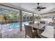 Covered patio with a dining set and a view of the sparkling pool at 3034 Mockingbird Ct, Clearwater, FL 33762