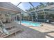 Lovely pool area featuring a screened-in lanai, dining, and lounge seating at 3034 Mockingbird Ct, Clearwater, FL 33762