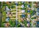 Birds-eye view of a residential neighborhood with mature trees, tidy lawns, and various home styles along the street at 321 Shore E Dr, Oldsmar, FL 34677