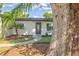 Charming single-story home with a well-manicured lawn, fresh landscaping, and a dark front door at 321 Shore E Dr, Oldsmar, FL 34677
