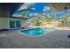 Secluded backyard pool inside a screened enclosure, surrounded by lush tropical foliage and a spacious patio at 321 Shore E Dr, Oldsmar, FL 34677