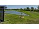 Backyard view features a tranquil pond with tropical trees and a manicured lawn at 34135 White Fountain Ct, Wesley Chapel, FL 33545