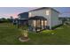 A screened-in patio area is set up in a well manicured backyard at 34135 White Fountain Ct, Wesley Chapel, FL 33545