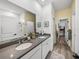 Bathroom features a walk-in shower, double sinks, quartz countertop, tile floor, and view to the closet at 34135 White Fountain Ct, Wesley Chapel, FL 33545