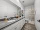 Clean bathroom showcasing double sinks, a neutral shower curtain, and tiled floors, blending style and functionality at 34135 White Fountain Ct, Wesley Chapel, FL 33545