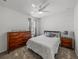 Well-lit bedroom featuring a comfortable bed, dresser, neutral decor, and a modern ceiling fan at 34135 White Fountain Ct, Wesley Chapel, FL 33545