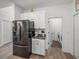 A modern kitchen boasts white cabinets, gray countertops and a stainless steel refrigerator at 34135 White Fountain Ct, Wesley Chapel, FL 33545