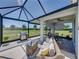 Enclosed patio with seating, fire pit, grill and serene backyard views at 34135 White Fountain Ct, Wesley Chapel, FL 33545