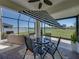 Enclosed patio boasting a dining table, fan, and relaxing views of the pond at 34135 White Fountain Ct, Wesley Chapel, FL 33545