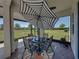 Enclosed patio boasting a dining table, umbrella, and relaxing views of the yard at 34135 White Fountain Ct, Wesley Chapel, FL 33545