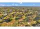 Aerial shot of a golf community featuring tree-lined fairways, manicured greens, and residences amid lush landscape under a blue sky at 3957 Tarpon Pointe Cir, Palm Harbor, FL 34684
