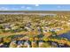 Overhead view of golf community featuring residences bordering a lush, tree-lined golf course, and a lake in the background at 3957 Tarpon Pointe Cir, Palm Harbor, FL 34684