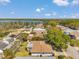 Aerial view showcasing a neighborhood near a lake with lush greenery, single Gathering homes, and blue skies at 3957 Tarpon Pointe Cir, Palm Harbor, FL 34684