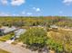 An aerial view showcases a residential street with mature trees, manicured lawns, and well-maintained homes at 3957 Tarpon Pointe Cir, Palm Harbor, FL 34684