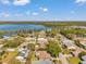 An aerial view shows a charming community next to a lake, with well-maintained homes and mature trees at 3957 Tarpon Pointe Cir, Palm Harbor, FL 34684