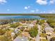 This aerial image showcases a neighborhood near a serene lake, featuring homes surrounded by lush greenery and trees at 3957 Tarpon Pointe Cir, Palm Harbor, FL 34684
