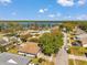Aerial view of a neighborhood with lush trees, well-maintained homes, and a lake in the background at 3957 Tarpon Pointe Cir, Palm Harbor, FL 34684