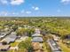 This aerial image shows an overview of homes with lush surroundings of trees, lawns, and blue skies above at 3957 Tarpon Pointe Cir, Palm Harbor, FL 34684