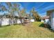 Spacious backyard with lush green grass, mature trees, and a privacy fence creating a peaceful retreat at 3957 Tarpon Pointe Cir, Palm Harbor, FL 34684