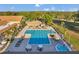 Community pool area with a large pool, lounge chairs, umbrellas, and lush green landscaping at 3957 Tarpon Pointe Cir, Palm Harbor, FL 34684